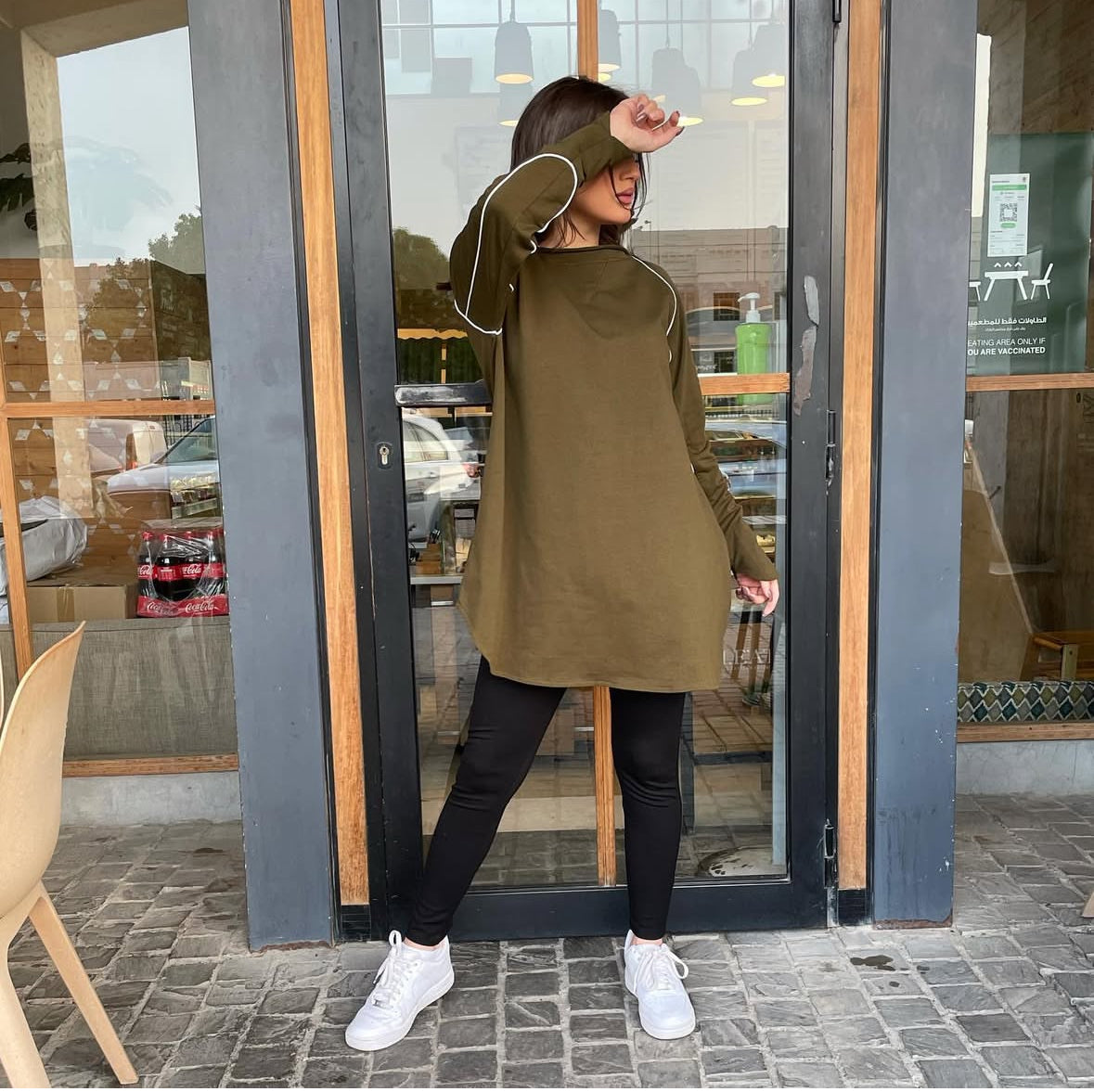 Woman wearing a Green Khaki active top with white thread detailing, suitable for sports or workouts