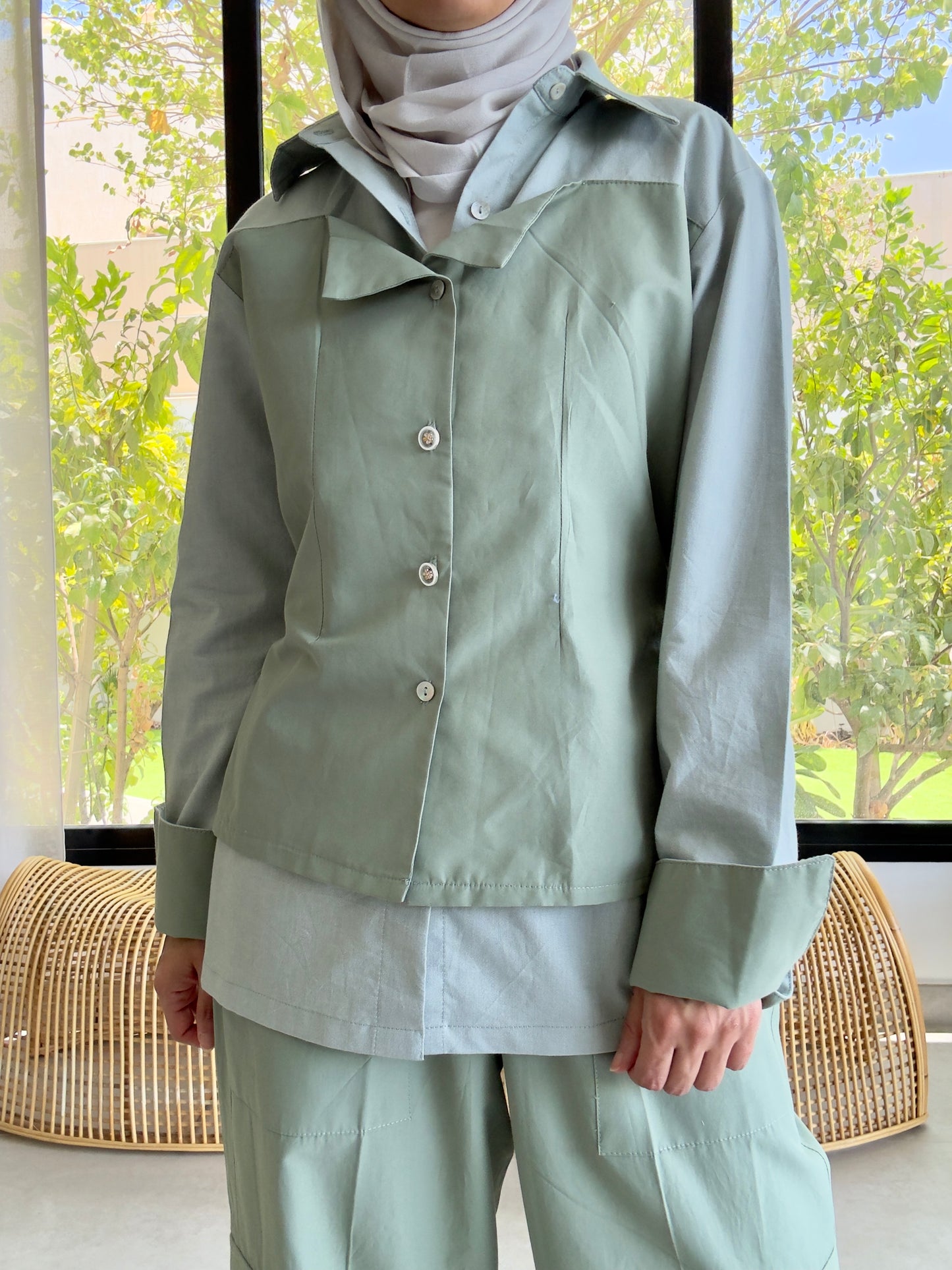 Women's light green modest outfit with jacket, pants, and headscarf, indoor photo
