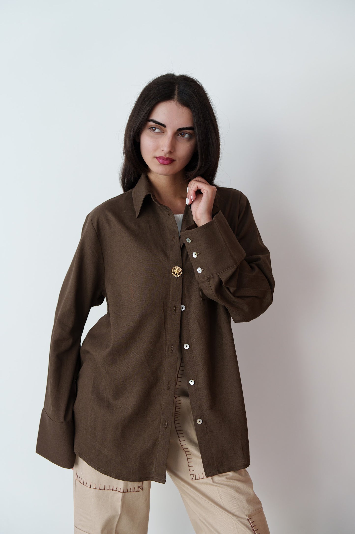 Woman wearing a brown shirt with a plain background