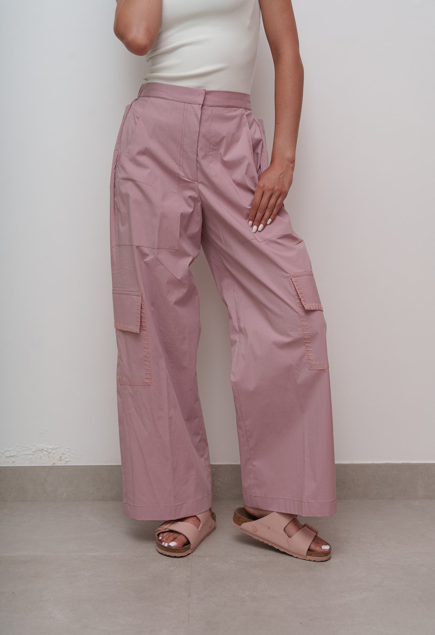 Person wearing pink cargo pants against a white background