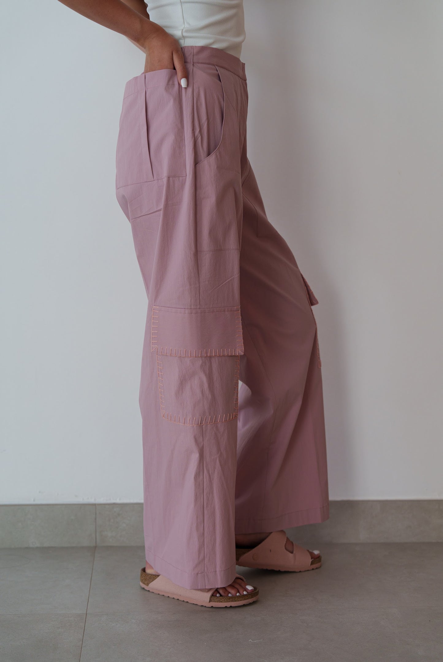 Person wearing pink wide-leg pants against a plain background