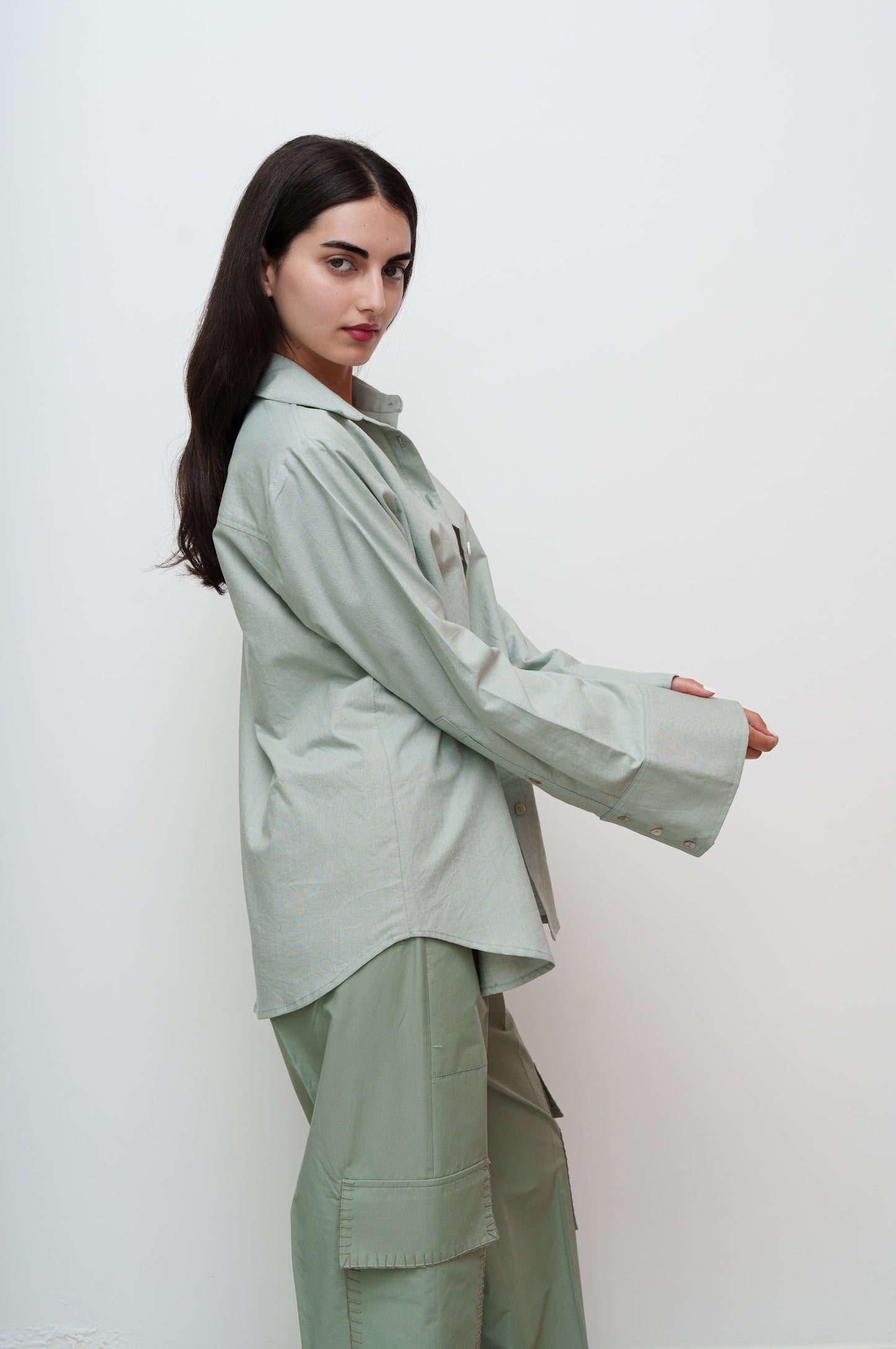 Woman wearing a light green outfit against a white background