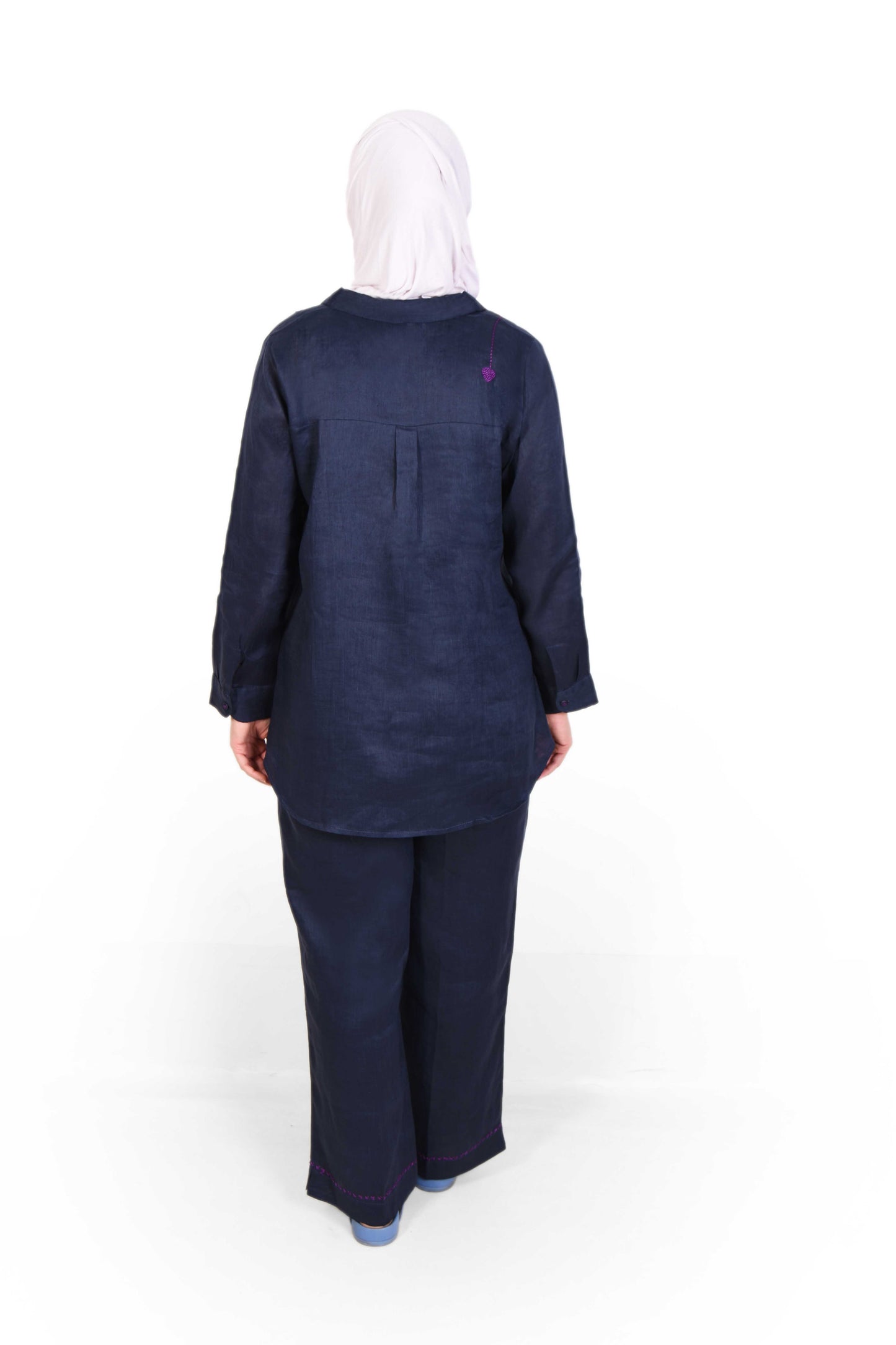 Backside view of modest outfit – navy blue cord with white hijab on plain white background