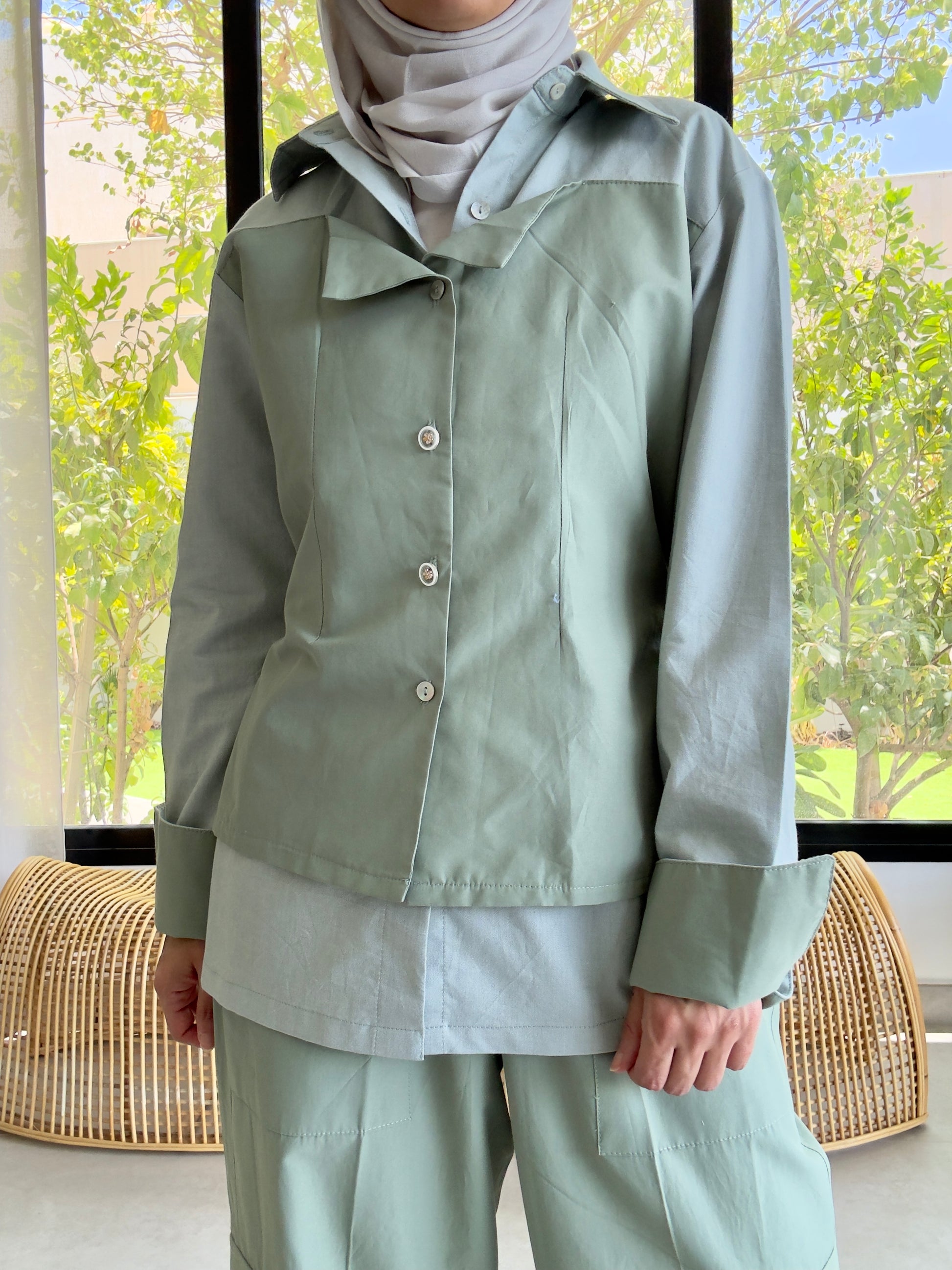 Women's light green modest outfit with jacket, pants, and headscarf, indoor photo
