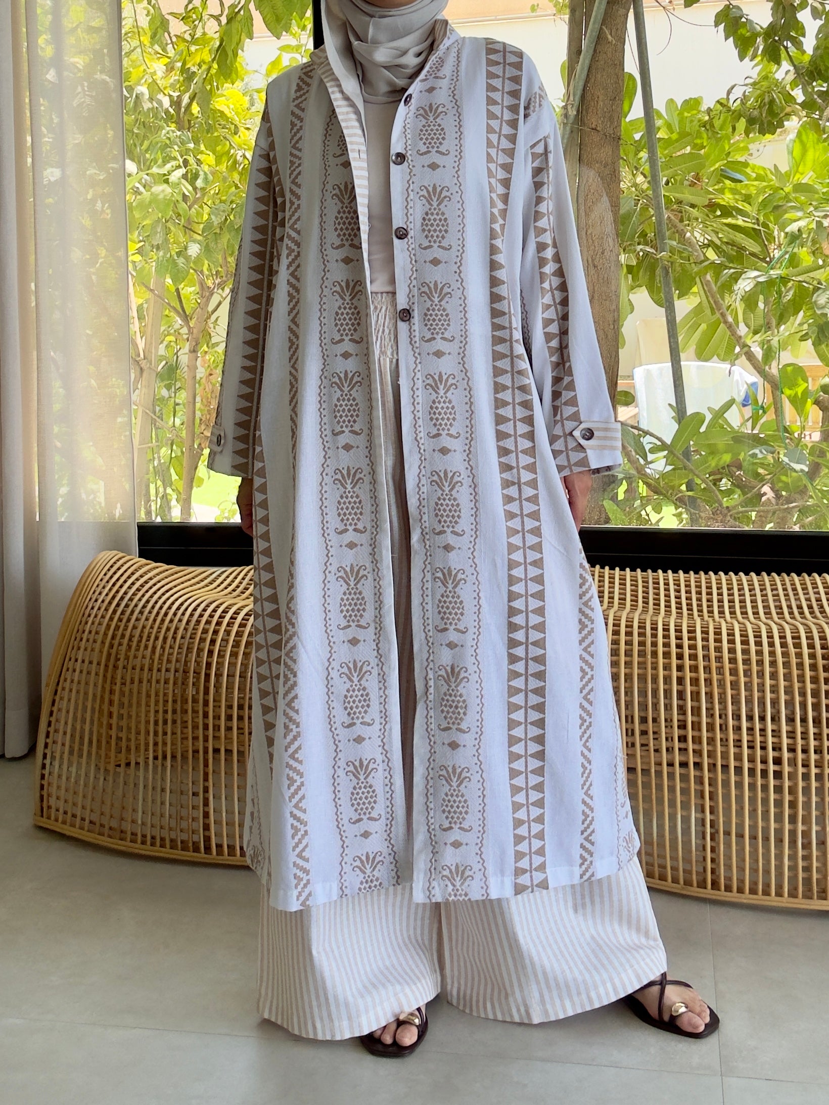 Light beige linen outfit with embroidery, worn by model, featuring lined top and comfy pants, blurred background