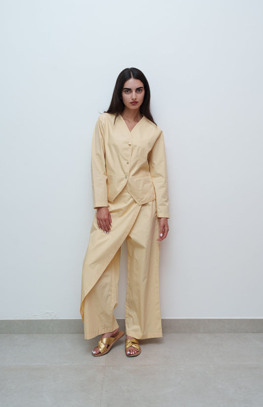 Woman wearing a beige outfit against a plain background