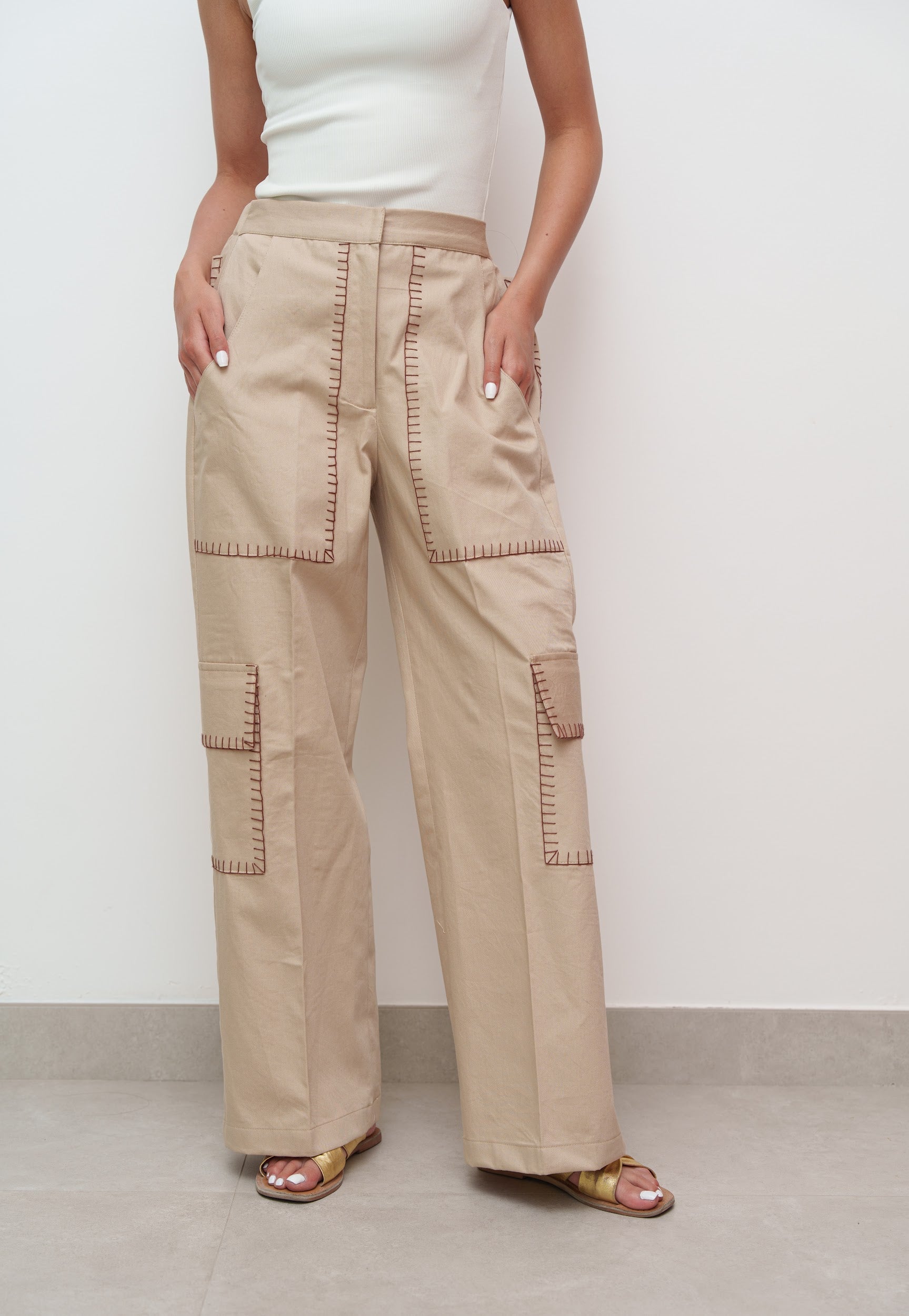 Person wearing beige cargo pants against a white background