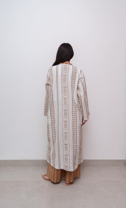 Rear angle of long patterned dress worn by woman, white background