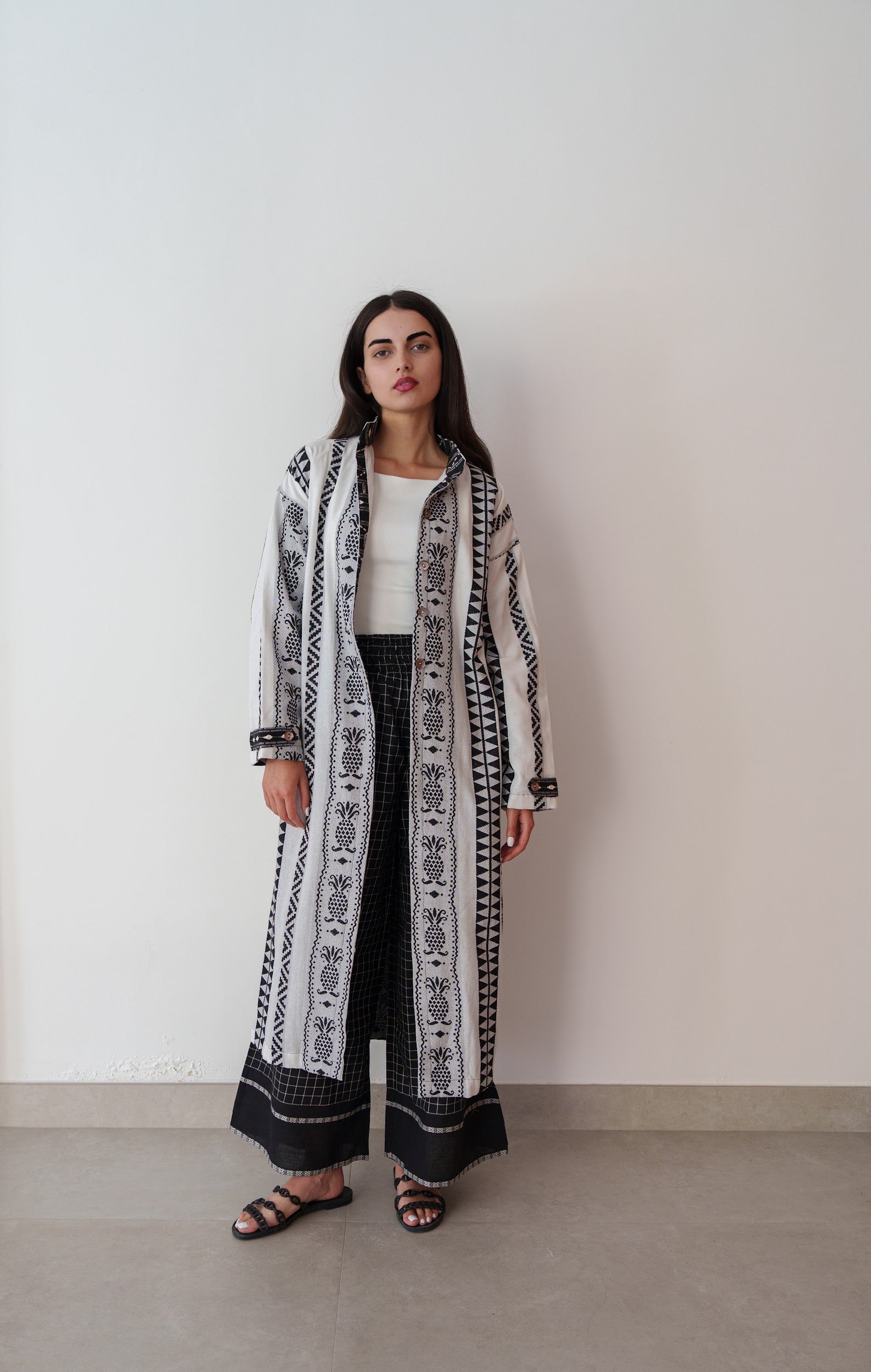 Model in black embroidered linen outfit with inner-lined top and comfortable matching pants, plain backdrop