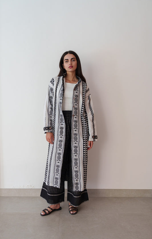 Model in black embroidered linen outfit with inner-lined top and comfortable matching pants, plain backdrop