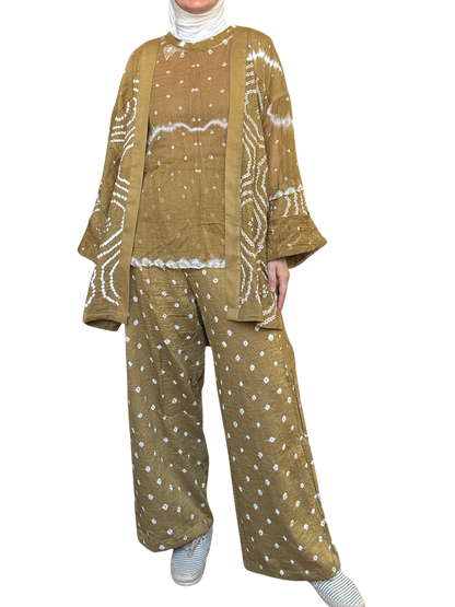 Woman wearing a patterned outfit with a jacket, top, and pants on a white background